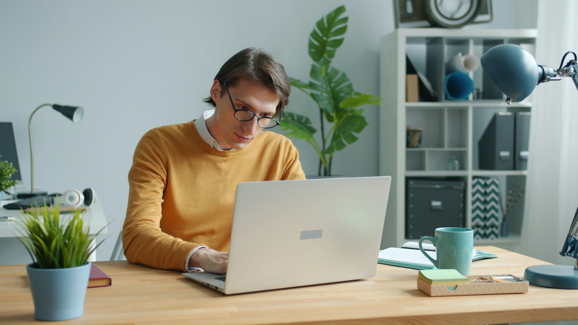 Web developer with glasses focused on reviewing a site audit report on a laptop.